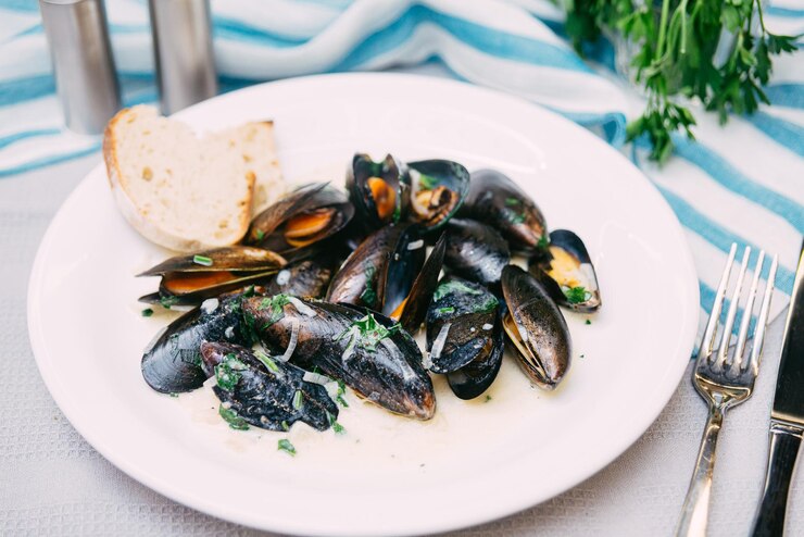 Foto schwarze muscheln in weißweinsauce gekocht und mit frischer petersilie bestreut