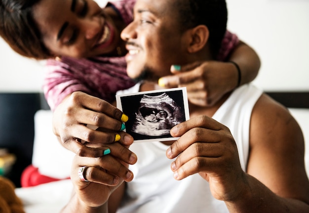 Schwarze Paare, die Babyultraschallscan-Foto zeigen