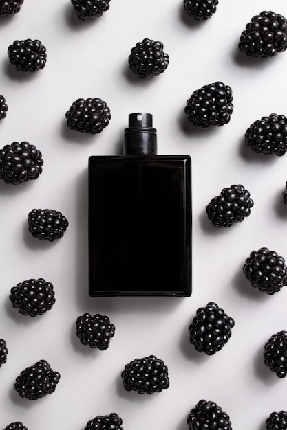 Schwarze Parfümflasche mit Brombeeren Konzept teurer Parfüms und Kosmetika Essenz für Männer