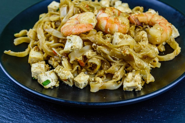 Schwarze Platte mit Pad Thai auf einer Schieferplatte