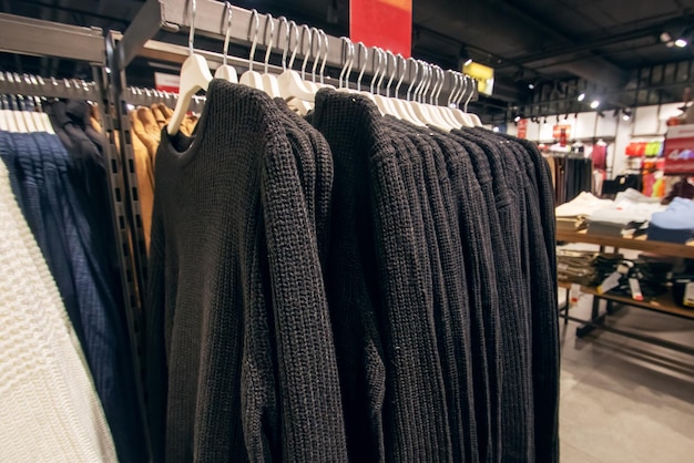 Schwarze Pullover auf Hängern im Laden in Nahaufnahme