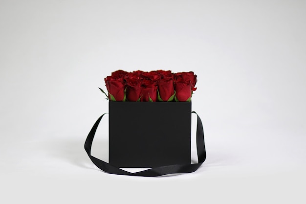 Schwarze quadratische Geschenk-Blumenbox mit roten Rosen im Inneren