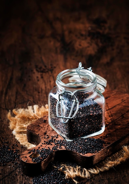 Schwarze Quinoa-Samen im Glas Vintage Küchentisch Hintergrund selektiven Fokus