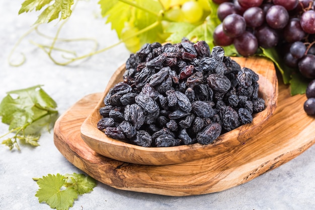 Schwarze Rosinen in der Schüssel auf Steinhintergrund