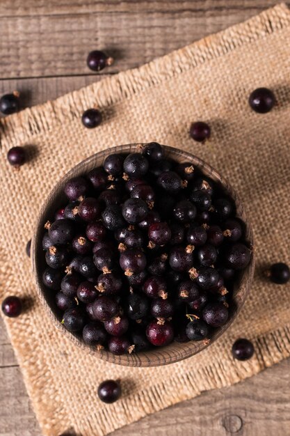 Schwarze Rosinen in einer Schüssel auf Holzgrund Bio-Beeren