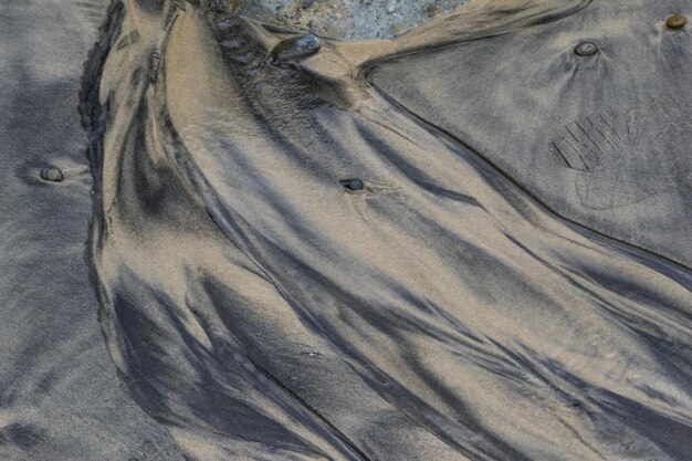 Schwarze Sandstruktur am Strand