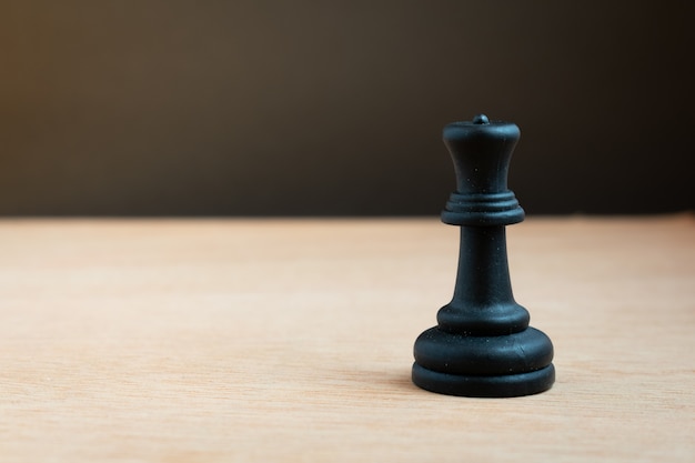 Schwarze Schachkönigin mit schwarzem Hintergrund