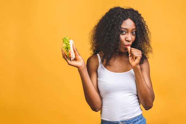 Schwarze schöne junge Frau des Afroamerikaners, die Hamburger isst