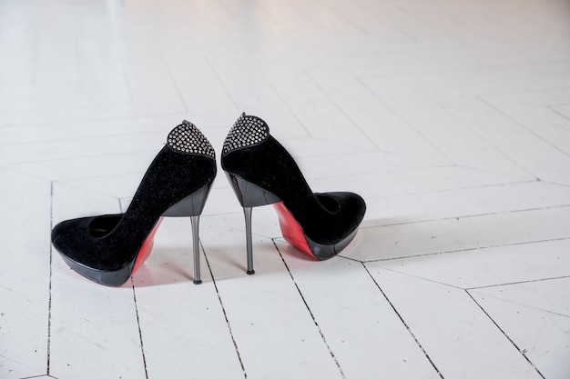 Schwarze Schuhe aus Wildleder mit hohem Absatz und dekorativem Schleifenelement mit glänzenden Strasssteinen an der Ferse