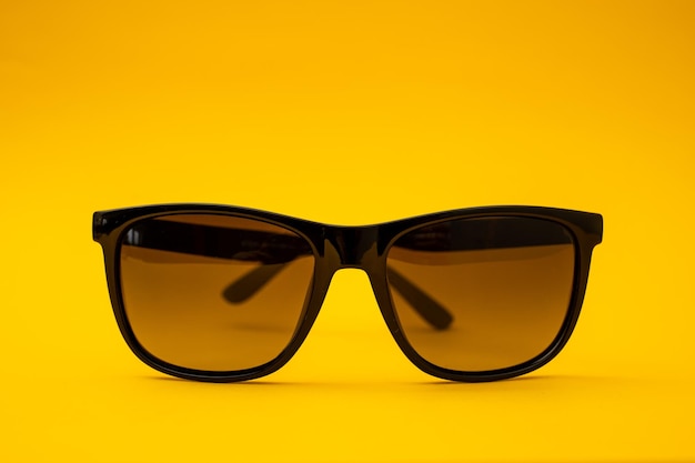 Schwarze Sonnenbrille auf orangefarbenem Hintergrund