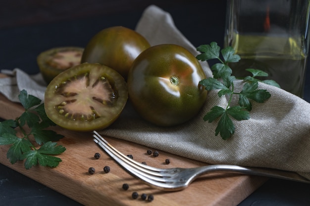 schwarze Tomaten auf einem Schneidebrett