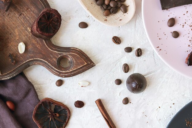 Schwarze und Milchschokolade Süßigkeiten getrocknete Zitrusfrüchte Kaffeebohnen und Gewürze auf dem Tisch