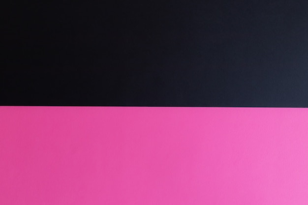Schwarze und rosa pastellfarbene Papieroberfläche mit Platz für Text