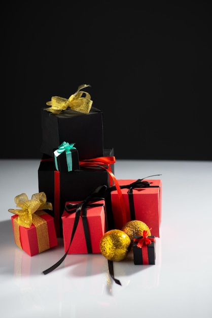 Schwarze und rote Geschenkboxen auf weißem Tisch und schwarzem Hintergrund