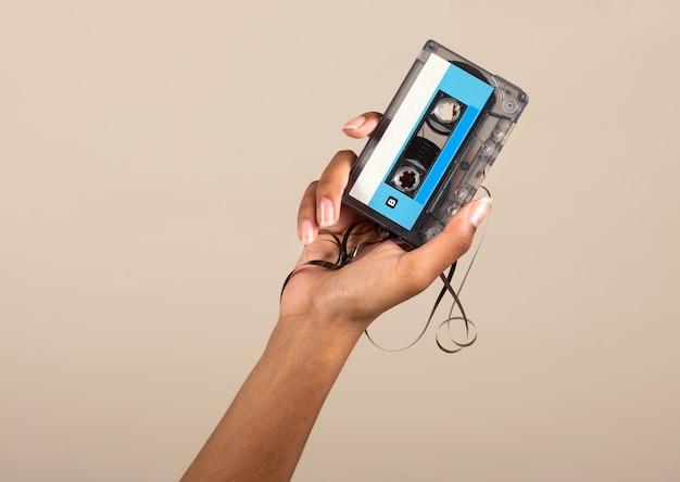 Schwarze weibliche Hand, die Vintage-Kassette zeigt