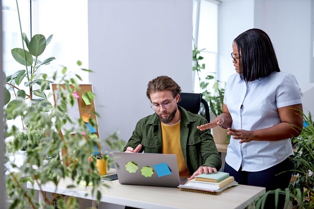 Schwarze weibliche Managerberatung im Gespräch mit einem Kollegen im Büro