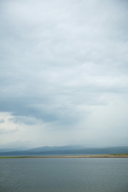 Foto schwarze wolken mit regen in bergen und über wasser