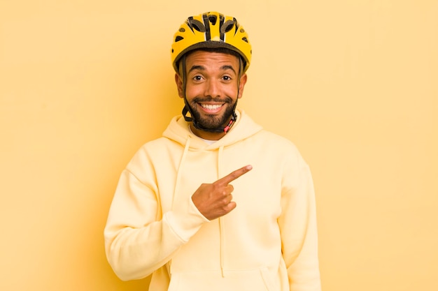 Schwarzer Afro-Mann, der aufgeregt und überrascht aussieht und auf das Side-Bike-Konzept zeigt