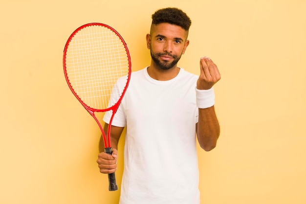 Schwarzer afro-mann, der capice oder geldgeste macht, die ihnen sagt, dass sie das tenniskonzept bezahlen sollen