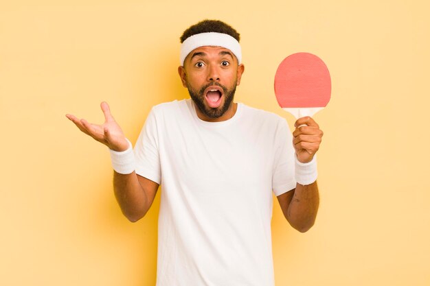 Schwarzer Afro-Mann, der sich extrem schockiert und überrascht über das Pingpong-Konzept fühlt