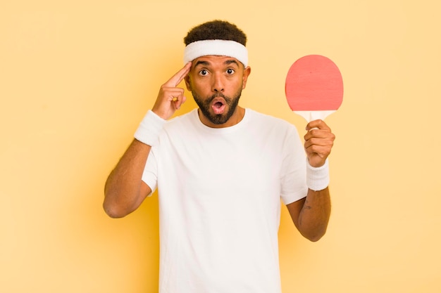 Schwarzer afro-mann, der überrascht aussieht, als er eine neue gedankenidee oder ein konzept-pingpong-konzept realisiert