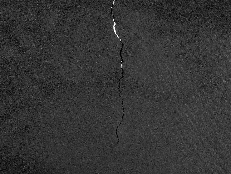 schwarzer Asphalt-Hintergrund mit Riss