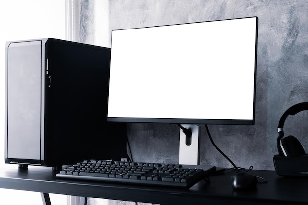 Schwarzer Computer mit weißem Bildschirm auf dem Schreibtisch