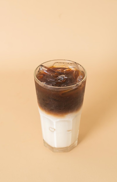 schwarzer Eiskaffee mit Milchschicht im Glas