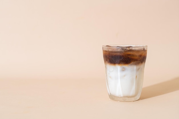 schwarzer Eiskaffee mit Milchschicht im Glas