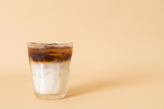schwarzer Eiskaffee mit Milchschicht im Glas