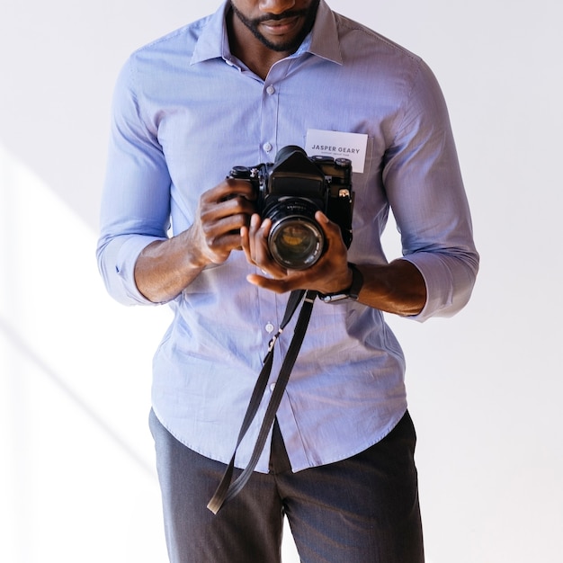 Schwarzer Fotograf mit einer sozialen Vorlage für eine Retro-Filmkamera
