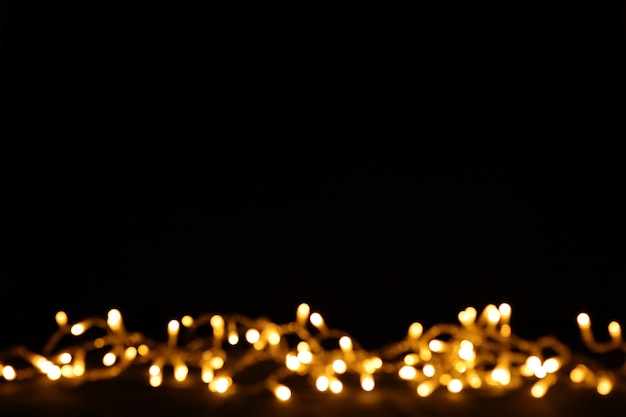 Schwarzer Hintergrund mit Weihnachtsbokeh-Lichtern. Freier Speicherplatz für Text, Kopienraum.