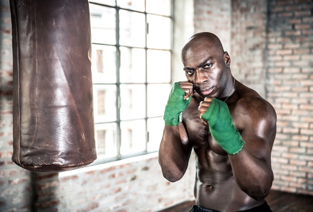 Schwarzer Kämpfer trainiert hart in seinem Fitnessstudio