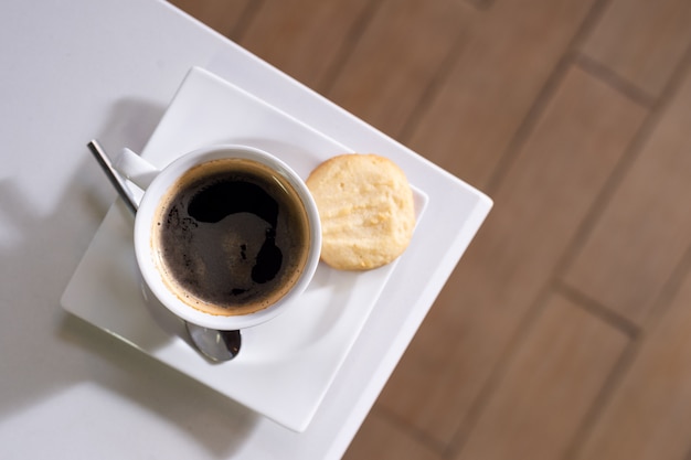 Schwarzer Kaffee auf weißen Tisch gestellt