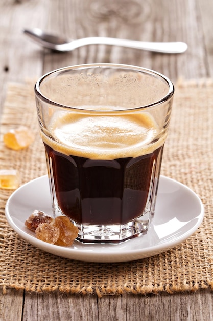 Schwarzer Kaffee im Glas mit Kristallzucker