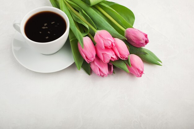 Schwarzer Kaffee im weißen Cup und in den Tulpen.