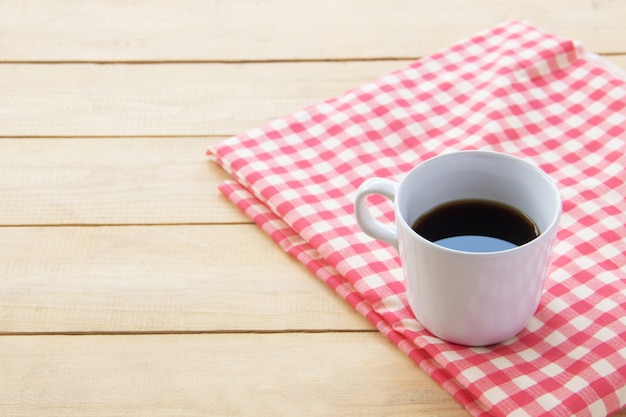 Schwarzer Kaffee in der weißen Schale auf hölzernem des Brauns