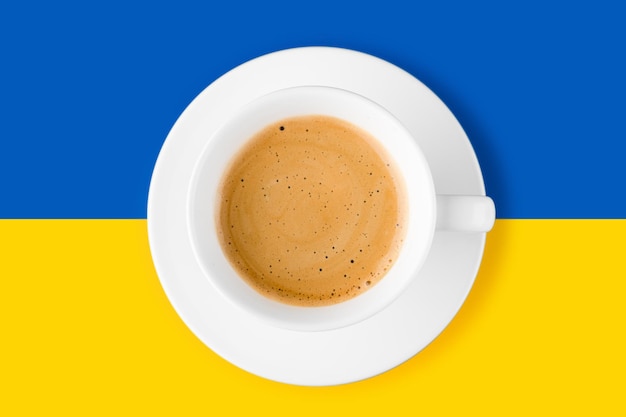Schwarzer Kaffee in einer Tasse auf blauem und gelbem Hintergrund der ukrainischen Flagge