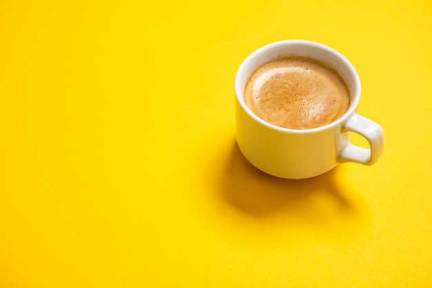 Foto schwarzer kaffee in einer tasse auf einem gelben