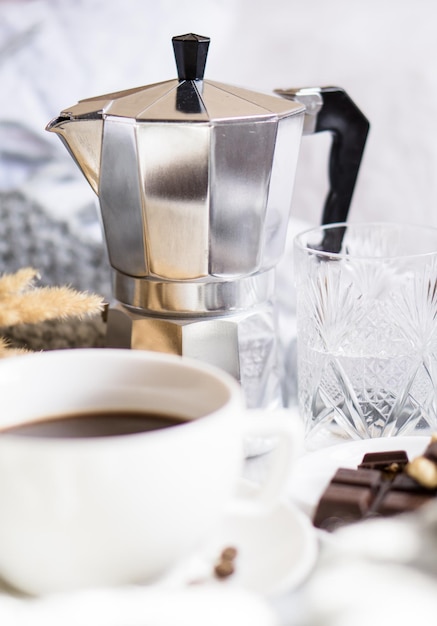 Schwarzer Kaffee in weißer Tasse im Bett