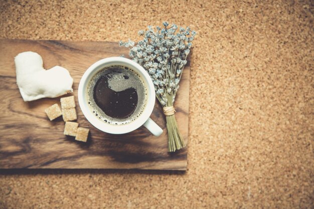 Schwarzer Kaffee in weißer Tasse mit Zucker, Karten, Tasche auf braunem Tischhintergrund