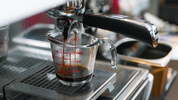 Schwarzer Kaffee mit Milch auf einer Kaffeemaschine