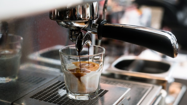 Schwarzer Kaffee mit Milch auf Kaffeemaschine