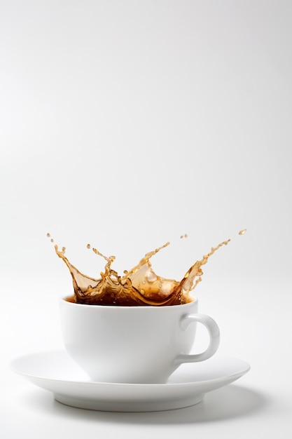 Schwarzer Kaffee spritzt in weiße Tasse