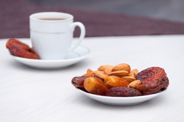 Schwarzer Kaffee und getrocknete Früchte auf Weiß