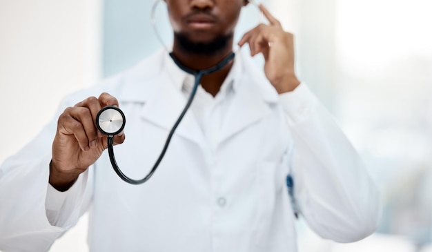 Schwarzer Mann Arzt Stethoskop in der Hand und Gesundheit mit medizinischen und Check-up im Krankenhaus Krankenversicherung und professioneller Medizinchirurg, der Herzschlag und Kardiologie hört