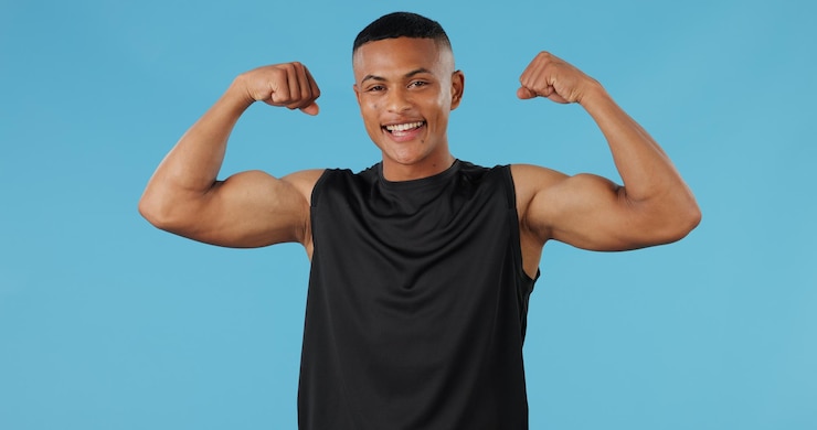 Foto schwarzer mann beugt arme und porträt im studio für wachstum muskeln oder fitness mit blauem hintergrund afrikanische person modell oder bodybuilder mit starkem lächeln oder entwicklung für wellness mit ergebnissen in kenia