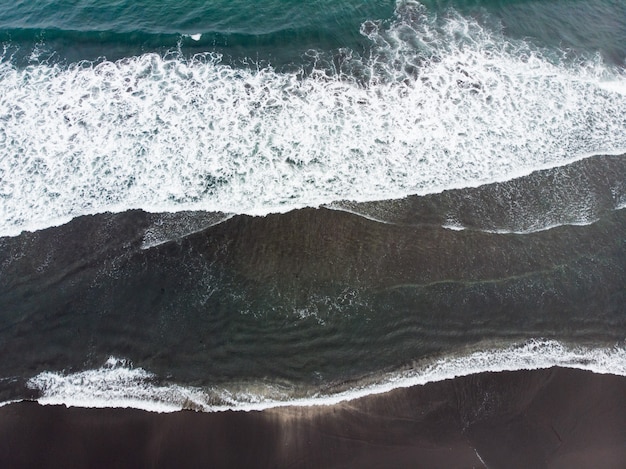 schwarzer Sandstrand von Reynisfjara und der Berg Reynisfjall vom Vorgebirge Dyrholaey an der Südküste Islands.