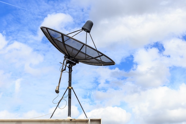 Schwarzer Satellit installieren auf dem Hausdach mit Hintergrund des blauen Himmels