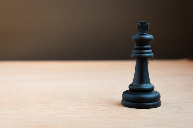 Schwarzer Schachkönig mit schwarzem Hintergrund